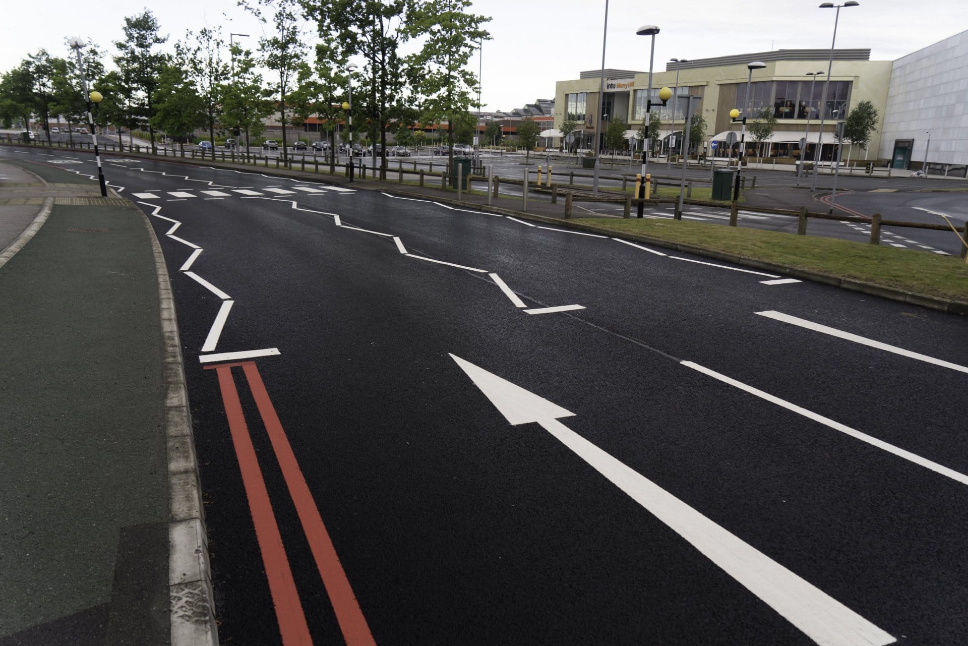 Photo of a UK road with some of the white lane markings in a diagonal back-and-forth pattern